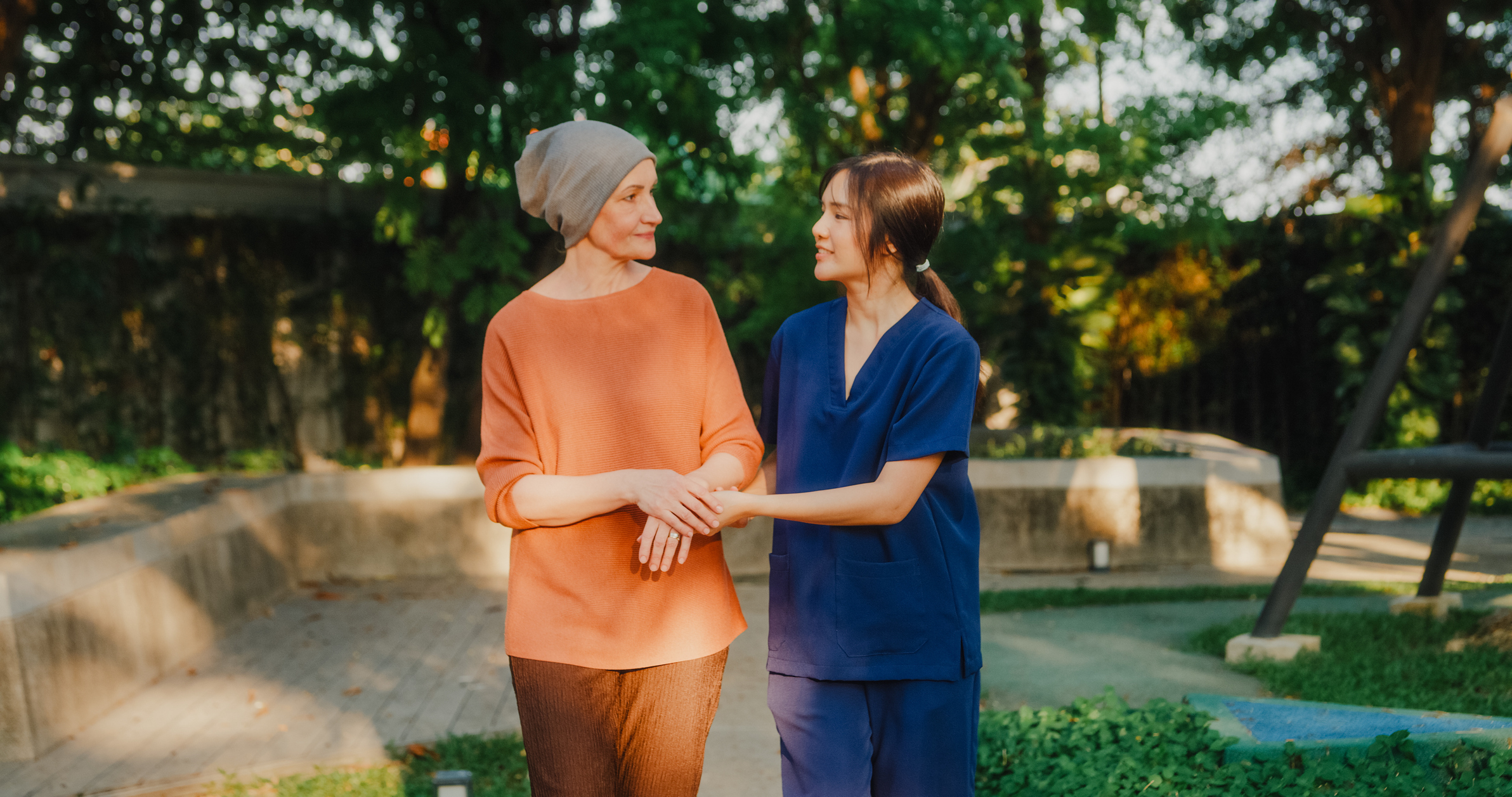 Patient and nurse walking together outdoors — life beyond treatment